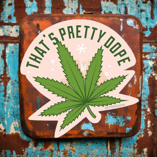 Sticker with green cannabis leaf and text 'THAT'S PRETTY DOPE' on a pink background